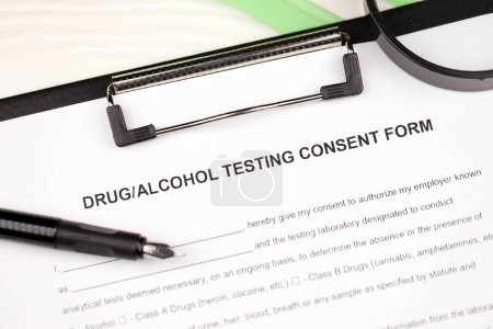 Téléchargez les photos : Formulaire de consentement aux tests de drogues et d'alcool sur tablette A4 se trouve sur la table de bureau avec stylo et loupe gros plan - en image libre de droit