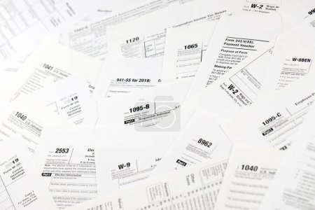 Photo for Many tax form blanks lies on table close up. Tax payers paperwork routine and bureaucracy concept. Need help with tax problems - Royalty Free Image