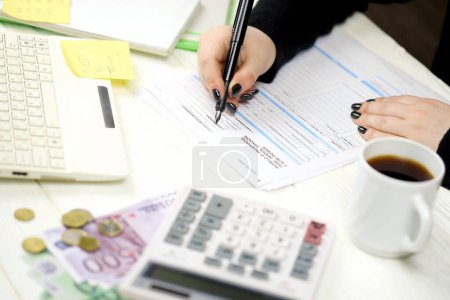 Photo for Accountant fill italian tax form F23 Payment model taxes duties penalties and other revenues in end of tax period. Taxation and paperwork routine in Italy - Royalty Free Image