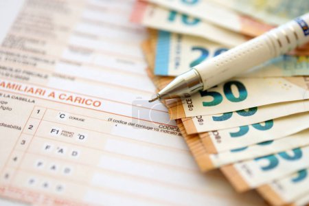 Foto de Rellenar el proceso de formulario de impuestos italiano con bolígrafo y billetes de dinero en euros de cerca. Período de pago y plazo - Imagen libre de derechos
