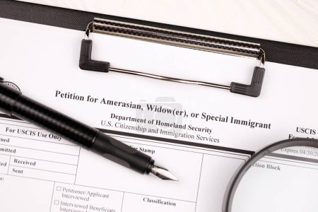 Photo for I-360 Petition for Amerasian, Widower or special immigrant blank form on A4 tablet lies on office table with pen and magnifying glass close up - Royalty Free Image