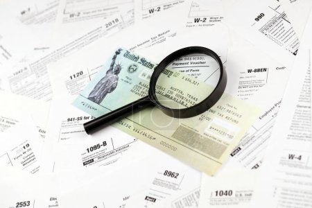 Photo for Refund check on many tax form blanks lies on table close up. Tax payers paperwork routine and bureaucracy concept - Royalty Free Image