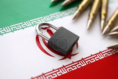 Photo for Small padlock lies on pile of iranian flag and rifle bullets close up. Sanctions, ban or embargo due to armed terror concept - Royalty Free Image