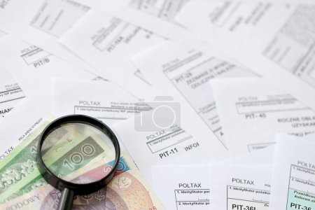 Photo for Polish zloty money and magnifying glass on big amount of polish tax forms close up. Accounting, bureaucracy and taxpayers routine in Poland - Royalty Free Image