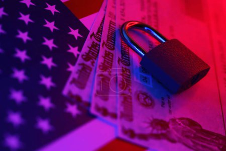 Téléchargez les photos : États-Unis Trésor chèque de remboursement ou de stimulus projet de loi avec petit cadenas sur le drapeau américain gros plan - en image libre de droit