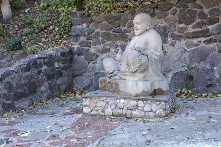 Foto de Cherkasy, UCRANIA - 20 de octubre de 2021 Gozosa estatua gris de hormigón de Buddah cerca del templo budista White Lotus en Cherkasy, Ucrania - Imagen libre de derechos