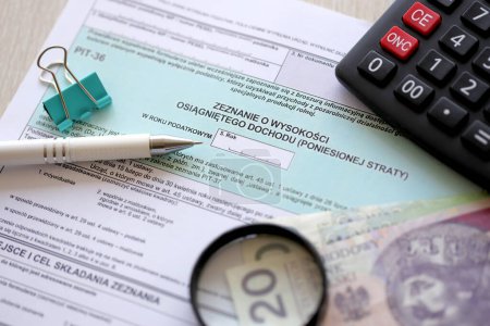 Erklärung der Höhe des verdienten Einkommens oder des entstandenen Verlustes, Steuerformulare PIT-36 auf dem Tisch des Buchhalters mit Stift und polierten Zloty-Geldscheinen in der Nähe