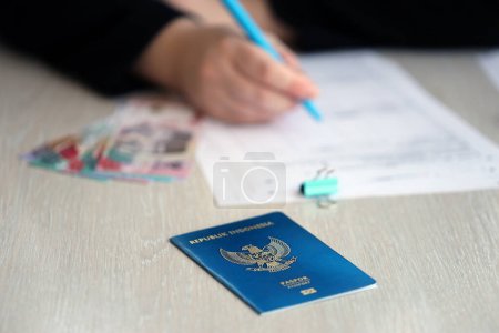 Téléchargez les photos : Indonésie table des travailleurs des passeports et des services sur le processus d'enregistrement de la citoyenneté. Une travailleuse remplit des papiers de citoyenneté - en image libre de droit