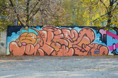 La antigua pared decorada con manchas de pintura en el estilo de la cultura del arte callejero. Fondo colorido de la pintura de graffiti completa con contornos brillantes en aerosol en la pared. Textura de fondo coloreado
