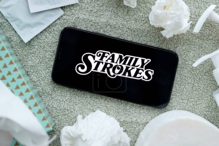 Photo for KYIV, UKRAINE - JANUARY 23, 2024 FamilyStrokes adult content website logo on display of iPhone 12 Pro smartphone - Royalty Free Image