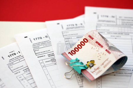 Indonesische Steuerformulare 1770 Individuelle Einkommensteuererklärung und Geld auf dem Tisch hautnah