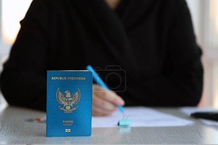 Téléchargez les photos : Indonésie table des travailleurs des passeports et des services sur le processus d'enregistrement de la citoyenneté. Une travailleuse donne un passeport - en image libre de droit