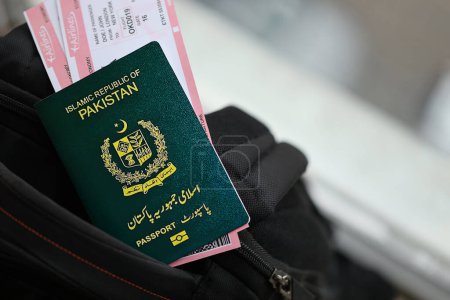 Grüner Pass der Islamischen Republik Pakistan mit Flugtickets auf Touristenrucksack in Großaufnahme. Tourismus- und Reisekonzept