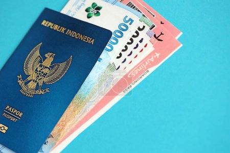 Reisepass der Blauen Republik Indonesien mit Geld und Flugtickets auf blauem Hintergrund in Großaufnahme. Tourismus- und Reisekonzept
