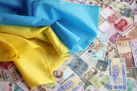 Téléchargez les photos : Drapeau ukrainien sur de nombreux billets de différentes devises. Contexte du financement de la guerre et du prix du soutien militaire en Ukraine - en image libre de droit