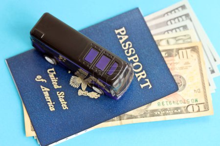 Passeport bleu des États-Unis d'Amérique avec argent et bus jouet sur fond bleu de près. Tourisme et concept de voyage