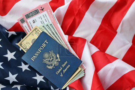 Blauer Pass der Vereinigten Staaten von Amerika mit Geld und Flugtickets auf dem Hintergrund der US-Flagge in Großaufnahme. Tourismus- und Reisekonzept