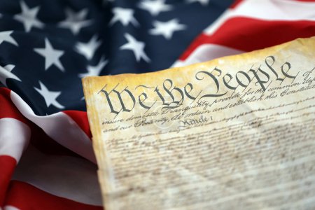 Foto de Preámbulo a la Constitución de los Estados Unidos y a la Bandera Americana. Antiguo papel amarillo con texto We The People - Imagen libre de derechos