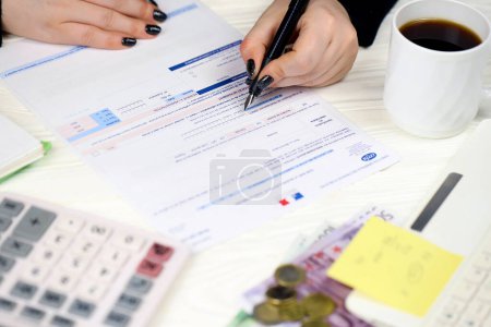 Téléchargez les photos : KYIV, UKRAINE - 31 OCTOBRE 2023 Le comptable remplit le formulaire CA12 Taxe sur la valeur ajoutée et taxes assimilées en fin de période fiscale. La fiscalité et la paperasserie en France - en image libre de droit