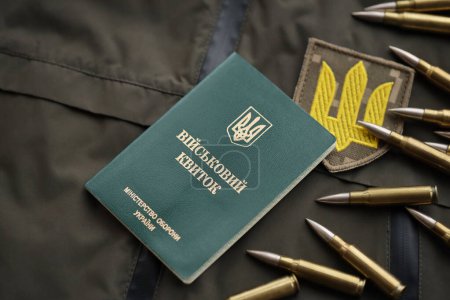Téléchargez les photos : Jeton militaire ou billet d'identité de l'armée se trouve sur vert uniforme militaire ukrainien à l'intérieur fermer - en image libre de droit