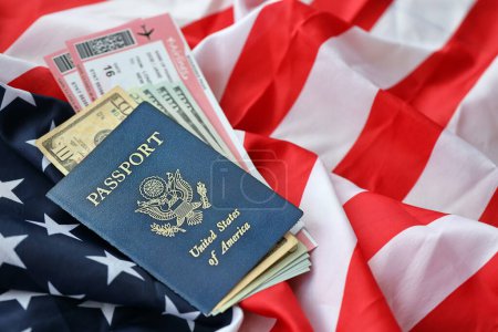 Blauer Pass der Vereinigten Staaten von Amerika mit Geld und Flugtickets auf dem Hintergrund der US-Flagge in Großaufnahme. Tourismus- und Reisekonzept