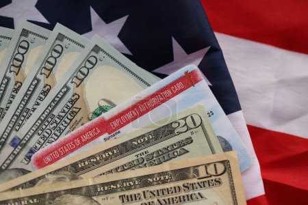Téléchargez les photos : Carte d'autorisation de travail États-Unis d'Amérique Permis de travail et billets en dollars sur le drapeau plié des États-Unis fermer - en image libre de droit