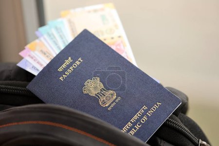 Passeport indien bleu avec de l'argent et des billets d'avion sur le sac à dos touristique fermer. Tourisme et concept de voyage