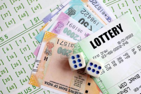 Téléchargez les photos : Billets de loterie verte et billets d'argent roupies indiennes à blanc avec des numéros pour jouer à la loterie fermer - en image libre de droit
