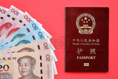 Roter Pass der Volksrepublik China und chinesische Yuan-Geldscheine. Chinesischer Pass der Volksrepublik China auf hellem Hintergrund in Nahaufnahme