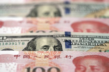 Many money bills of People Republic of China and United States. PRC Yuan and USD dollars banknotes close up