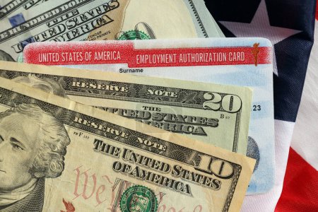 Foto de Tarjeta de Autorización de Empleo Estados Unidos de América Permiso de Trabajo y billetes de dólar en banderas plegadas - Imagen libre de derechos
