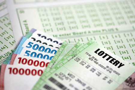 Grüne Lotterielose und indonesische Geldscheine auf Blanko mit Zahlen zum Lotteriespiel aus nächster Nähe