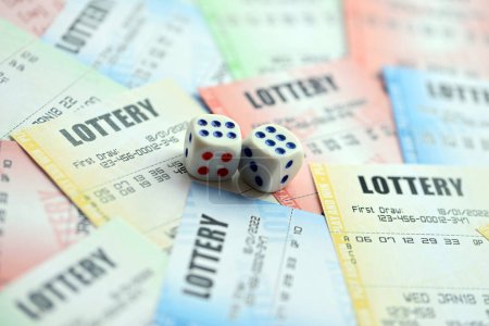 Muchos billetes de lotería y dados en billetes en blanco con números para jugar a la lotería de cerca