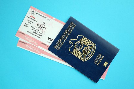 Blue United Arab Emirates passport with airline tickets on blue background close up. Tourism and travel concept