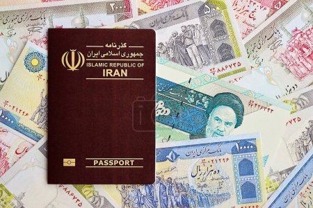 Photo for Red Islamic Republic of Iran passport and iranian reals money bills background close up. Tourism and travel concept - Royalty Free Image