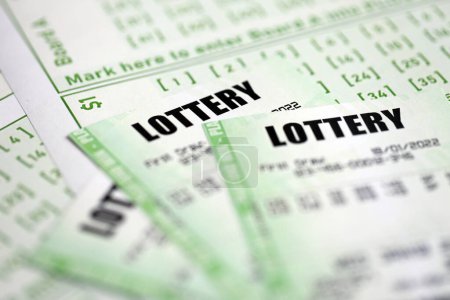 Billets de loterie verts et billets en blanc avec des numéros pour jouer à la loterie fermer