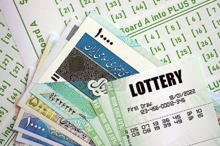 Green lottery tickets and iranian money bills on blank with numbers for playing lottery close up