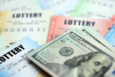 Viele Lotterielose und Dollarscheine auf Blankoscheinen mit Zahlen zum Lotteriespiel aus nächster Nähe