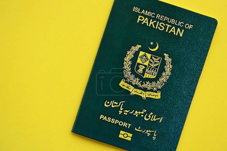 Grüner Pass der Islamischen Republik Pakistan auf gelbem Hintergrund in Großaufnahme. Tourismus- und Bürgerschaftskonzept