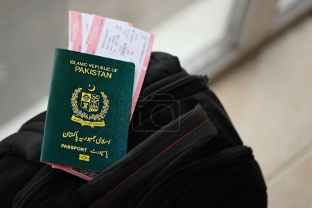 Grüner Pass der Islamischen Republik Pakistan mit Flugtickets auf Touristenrucksack in Großaufnahme. Tourismus- und Reisekonzept