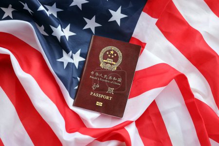 Pasaporte rojo de la República Popular China en la bandera de los Estados Unidos. pasaporte chino de la República Popular China sobre fondo brillante de cerca