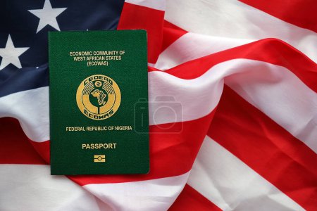 Grüner nigerianischer Pass auf dem Hintergrund der US-Nationalflagge in Großaufnahme. Tourismus- und Diplomatie-Konzept