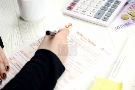 Photo for KYIV, UKRAINE - OCTOBER 31, 2023 Accountant fill italian tax form Modello 730 individual income tax return in end of tax period. Taxation and paperwork routine in Italy - Royalty Free Image