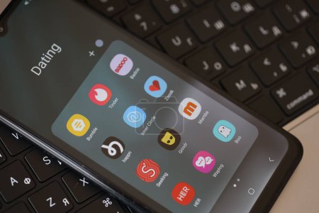 Foto de KYIV, UCRANIA - FEBRERO 28, 2024 Citas iconos de aplicaciones en la pantalla del teléfono inteligente en el teclado MacBook - Imagen libre de derechos