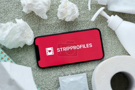Photo for KYIV, UKRAINE - JANUARY 23, 2024 StripProfiles adult content website logo on display of iPhone 12 Pro smartphone - Royalty Free Image