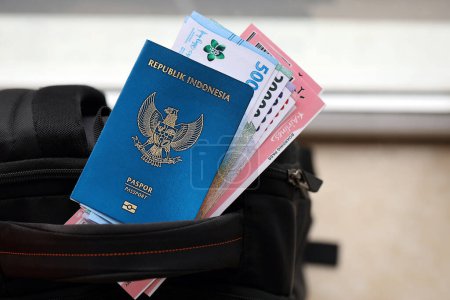Blaue Republik Indonesien Pass mit Geld und Flugtickets auf touristischen Rucksack aus nächster Nähe. Tourismus- und Reisekonzept