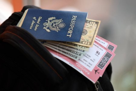 Passeport bleu des États-Unis d'Amérique avec de l'argent et des billets d'avion sur le sac à dos touristique fermer. Tourisme et concept de voyage