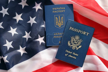 United States of America and Ukrainian Passports on folded US flag close up