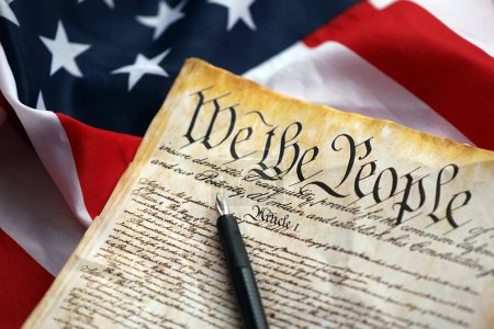 Preámbulo a la Constitución de los Estados Unidos y a la Bandera Americana. Antiguo papel amarillo con texto We The People