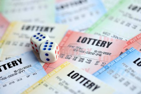 Photo for Many lottery tickets and dice on blank bills with numbers for playing lottery close up - Royalty Free Image
